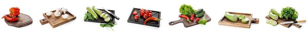 Set of wooden cutting boards with knives and fresh vegetables on white background - Photo, Image