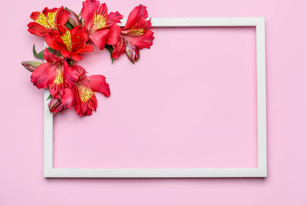 Komposition mit leerem Bilderrahmen und Alstroemeria-Blumen auf farbigem Hintergrund - Foto, Bild