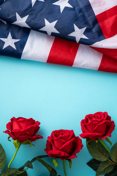 Concept of U.S Independence day or Memorial day. National flag over blue table background with red rose. - Photo, image