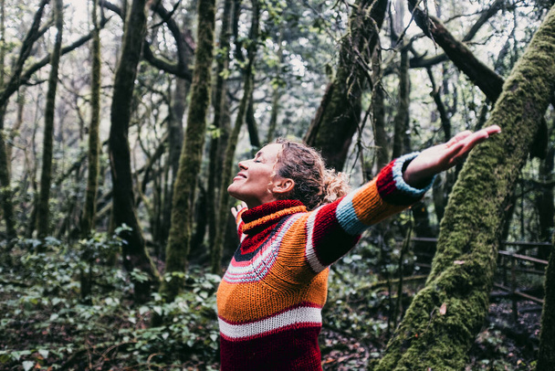 Heureuse femme adulte sourire et les bras ouverts pour embrasser la belle forêt naturelle autour d'elle. Concept de tourisme vert ambiant et durable. Jour de la Terre et amour pour les bois concept - Photo, image
