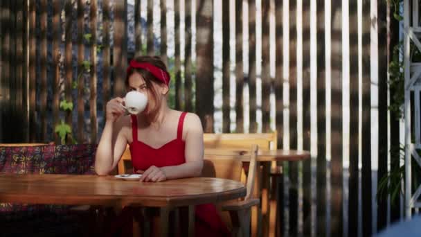 chica feliz en un café bebe café, disfrute en el verano y estilo de vida - Imágenes, Vídeo