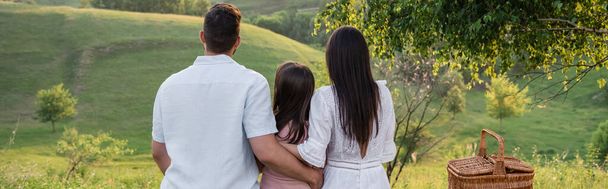 back view of family sitting in front of scenic landscape in countryside, banner - Foto, Bild