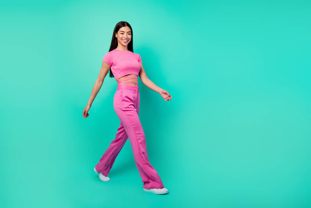 Full body profile side image of cheerful energetic lady in pink outfit go on walk isolated on turquoise color background. - Fotoğraf, Görsel