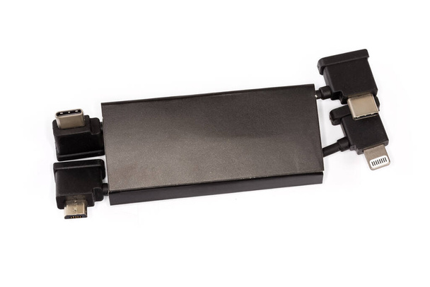 Deux câbles courts avec prises USB Type-C sur un bord et micro USB et Lightning respectivement sur les autres bords dans un emballage en carton sur un fond blanc - Photo, image