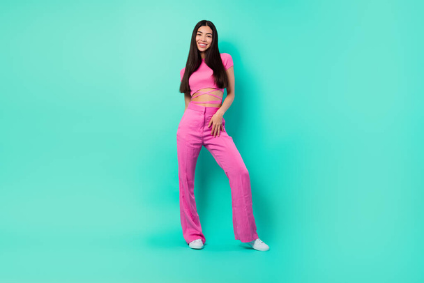 Full size picture of good looking female in trendy street style pink outfit set isolated on turquoise color background. - Foto, Imagem