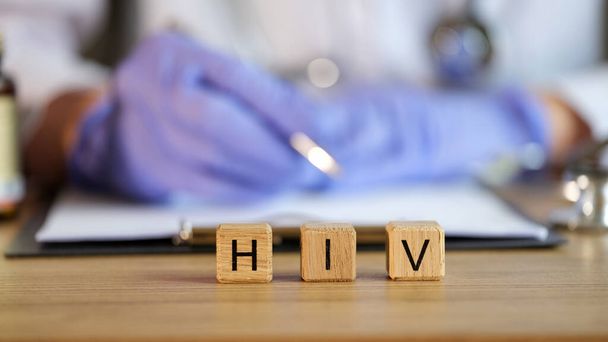 HIV text on cubes in medical clinic against background of doctor. Human immunodeficiency virus and treatment concept - Photo, Image