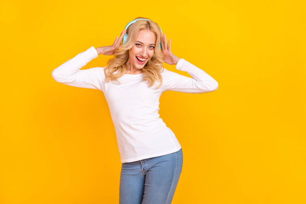 Photo of cool young blond lady dance wear shirt jeans isolated on yellow background. - Fotó, kép