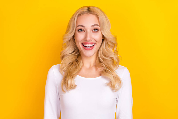 Photo of impressed pretty lady dressed white shirt smiling open mouth isolated yellow color background. - Zdjęcie, obraz
