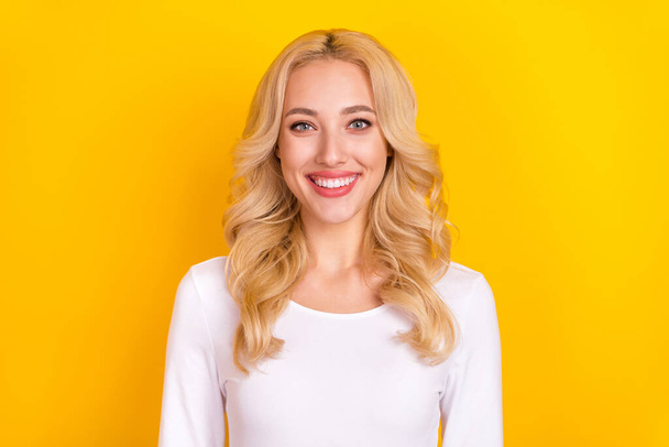 Photo of sweet funny girly young woman wear white shirt smiling isolated yellow color background. - 写真・画像