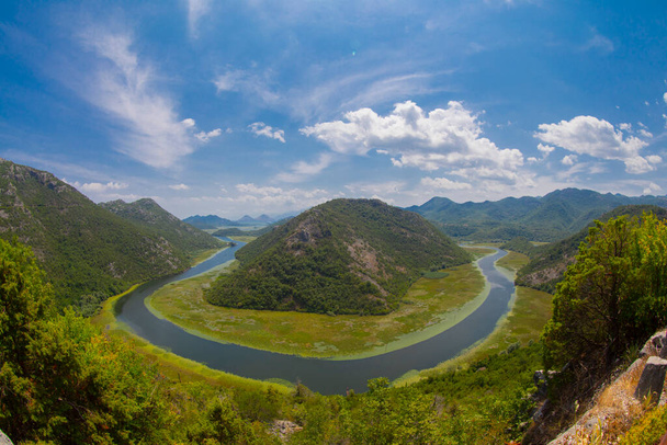 Vista da ponta ocidental do Lago Skadar, Montenegro. Rio Crnojevic curva em torno de picos de montanha verde. Excelente vista do rio
. - Foto, Imagem