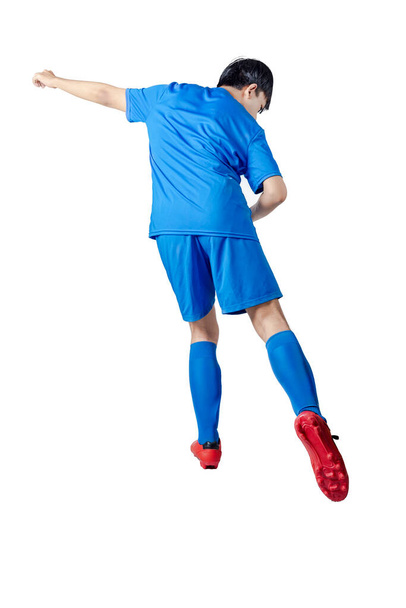 Rear view of football player man in a blue jersey with the pose of kicking the ball isolated over white background - Foto, Imagen