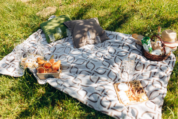 Summer picnic on sunny day with bread, fruit, bouquet hydrangea flowers, glasses wine - Fotografie, Obrázek