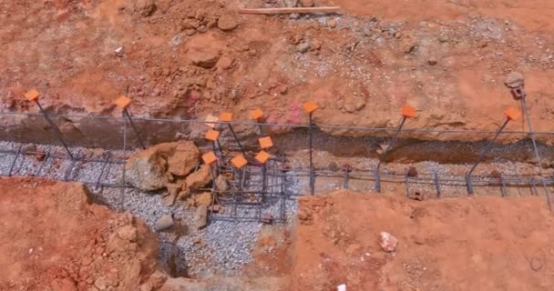 Tijdens de voorbereiding van een nieuw huis wordt een sleuf onder in de betonnen fundering gegraven een bovenaanzicht vanuit de lucht - Video