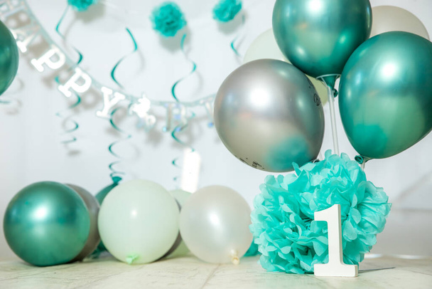 sliver, blue and white decoration for a 1st birthday cake smash studio photo shoot with balloons, paper decor, cake and topper. High quality photo - Zdjęcie, obraz
