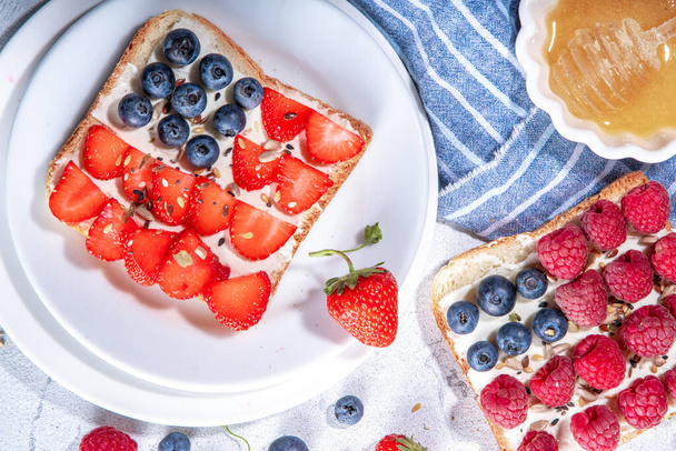 American holiday USA independence food, recipe idea July 4 breakfast or snack - sandwich with toast bread, cream cheese, blueberry raspberry, strawberry - Foto, Imagen