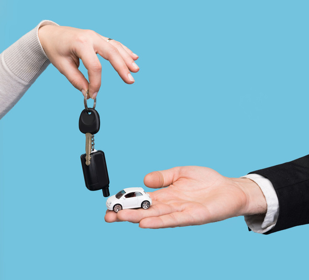 Man met kleine auto, vrouw auto knop ingedrukt - Foto, afbeelding