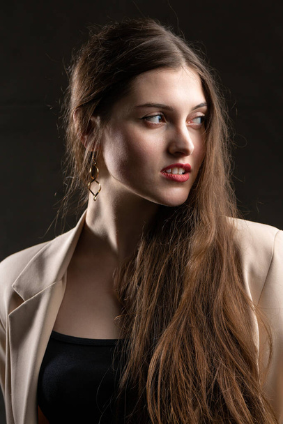 Retrato de uma jovem morena com cabelos longos no estúdio. Foto dramática em cores escuras. - Foto, Imagem