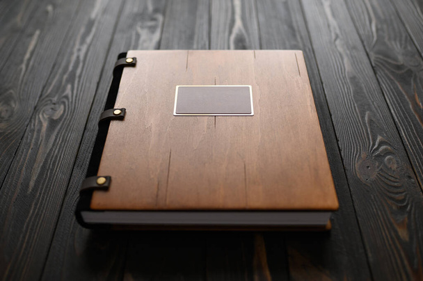Un viejo álbum de fotos con una cubierta de madera y un escudo en una mesa rústica. logo gratis - Foto, Imagen
