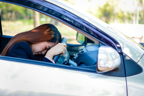Arabada oturan Asyalı iş kadını sürmekten yoruldu. Trafik yoğun saatlerde sıkışıktır. ulaşım kavramı, şehir sürüşü - Fotoğraf, Görsel