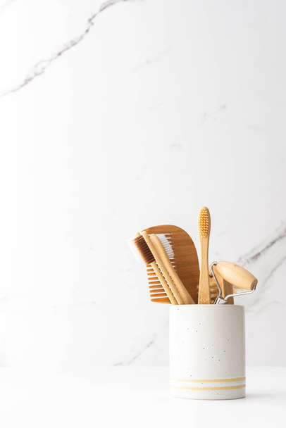 Wooden toothbrushes with natural bristles in a ceramic glass,face and skin care products, bath accessories, spa and beauty concept - 写真・画像