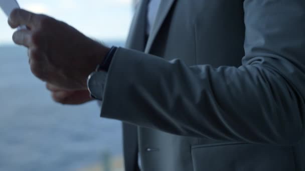 Angry man throw documents at panorama window. Man hands hold papers closeup. Unknown dissatisfied client investor checking drop contract agreement at sea view. Business partnership crisis concept. - Footage, Video