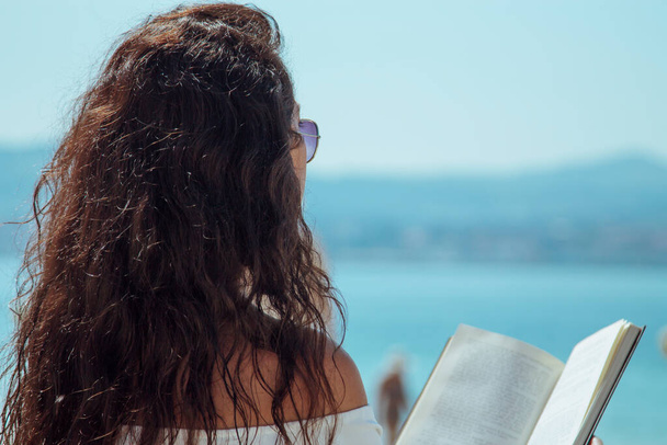 woman reading a book on the beach - Фото, изображение