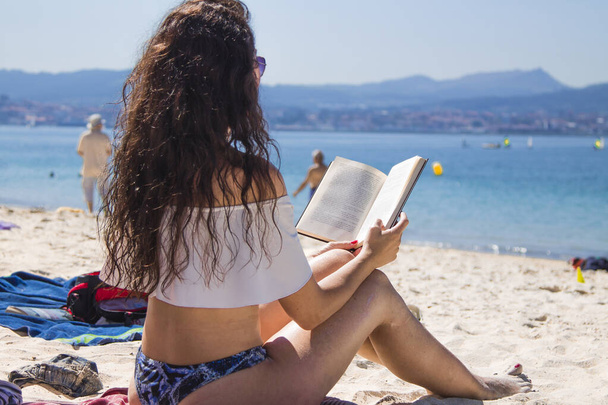 relaxed woman reading a book on the beach - Valokuva, kuva
