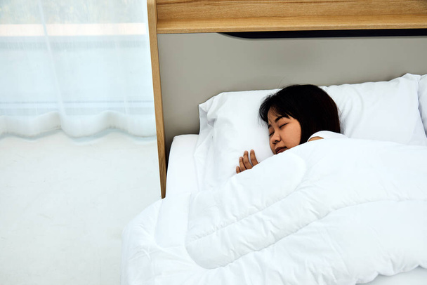 閉じるアップアジアの女性睡眠上の白いベッドでザ · ベッドルームで甘い夢と楽しい休息で自宅でコピースペース - 写真・画像