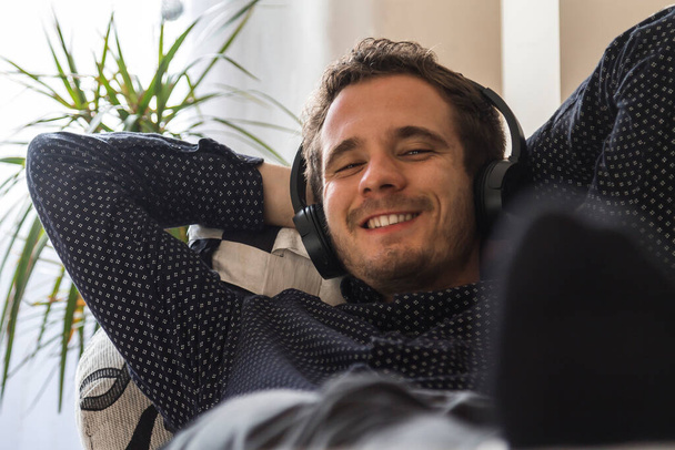 relaxed young man with headphones at home - Foto, imagen