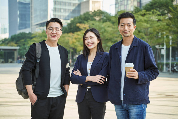 3人の若いアジア人が笑顔で立っている屋外の肖像画です - 写真・画像