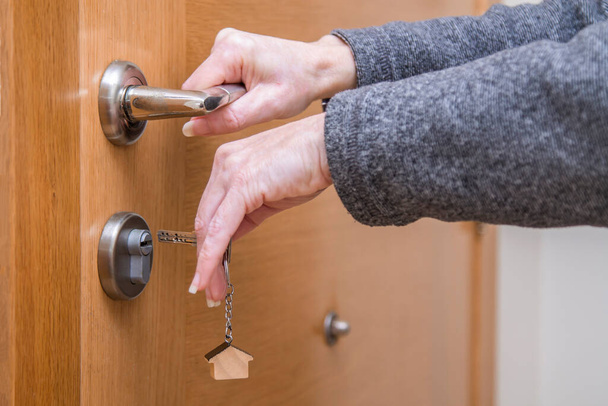 woman hands with key and door lock - Zdjęcie, obraz