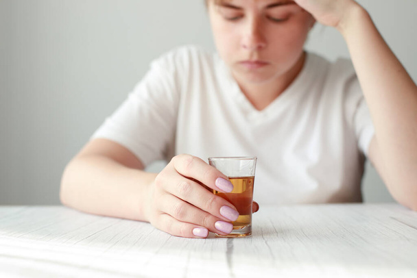 женщина со стаканом крепкого алкоголя крупным планом. женский алкоголизм - Фото, изображение
