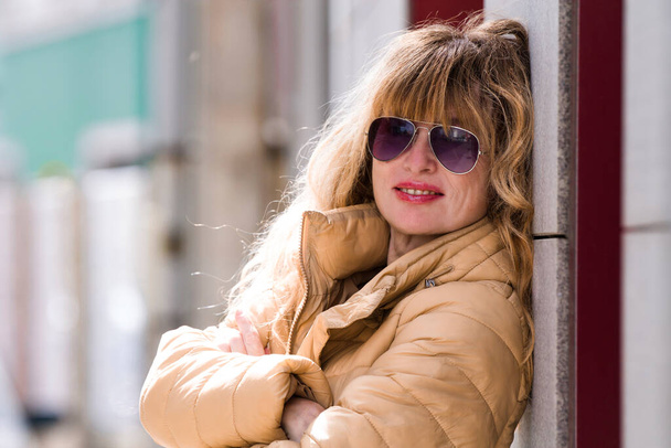 woman with sunglasses and coat on the street - Photo, Image