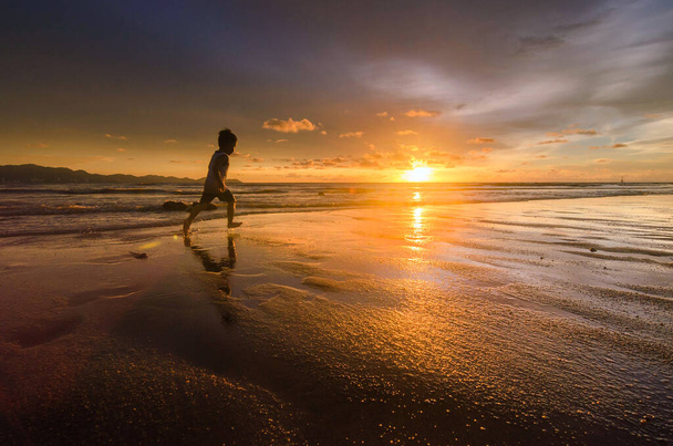 silhouette d'un homme sur la plage au coucher du soleil - Photo, image