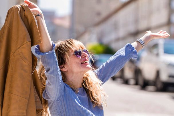 relaxed happy woman with arms raised on the streets of the city - Foto, Imagen