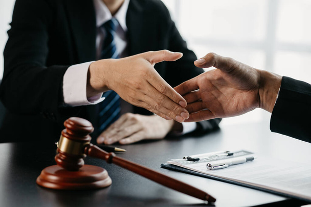 Lawyers shake hands with clients who come to testify in the case of embezzlement from business partners who jointly invest in the business. The concept of hiring a lawyer for legal proceedings. - Foto, Bild