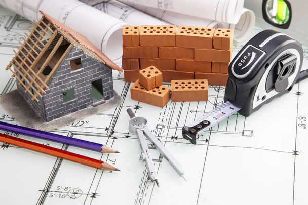 Budowa domu, plany i narzędzia budowlane wraz z kolorowym zegarkiem. Budownictwo - Zdjęcie, obraz