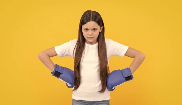 сердита дитина в боксерських рукавичках на жовтому фоні
. - Фото, зображення