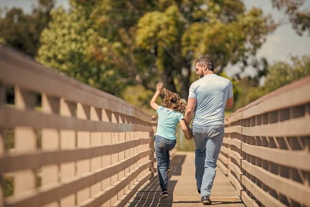 family value. childhood and parenthood. parent relax with little child boy. dad with kid on funny summer day. parenting and fatherhood. fathers day. back view. happy father and son running outdoor. - Photo, Image