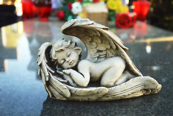 close-up van engel beeldje slapen op het graf - Foto, afbeelding