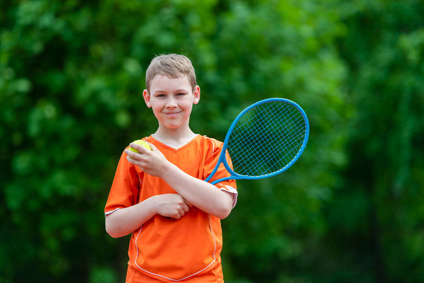 Lapsi tennismailalla tenniskentällä. Koulutus nuorelle lapselle, terveille lapsille. Horisontaalinen urheilu teema juliste, onnittelukortit, otsikot, verkkosivuilla ja sovellus - Valokuva, kuva