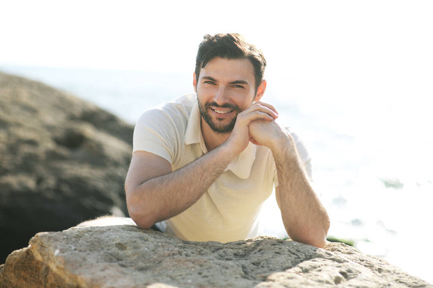 Young stylish smiling man outdoor portrait near the sea, smile with teeth braces - Фото, изображение