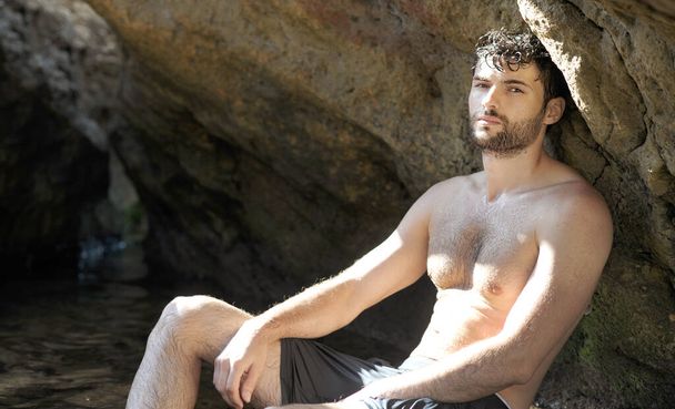 Young calm man outdoor portrait near sea cave, topless calm - Foto, afbeelding