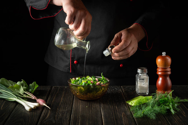 Šéfkuchař přidá do čerstvého salátu rostlinný olej. Příprava vegetariánské snídaně v kuchyni. - Fotografie, Obrázek