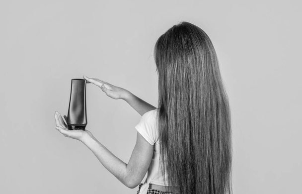 Time for new haircut. strong and resilient. girl condition hair with straightener. teen child cleaning hair with shampoo. kid presenting shower gel. body care cosmetic bath shower. skin lotion. - Фото, зображення