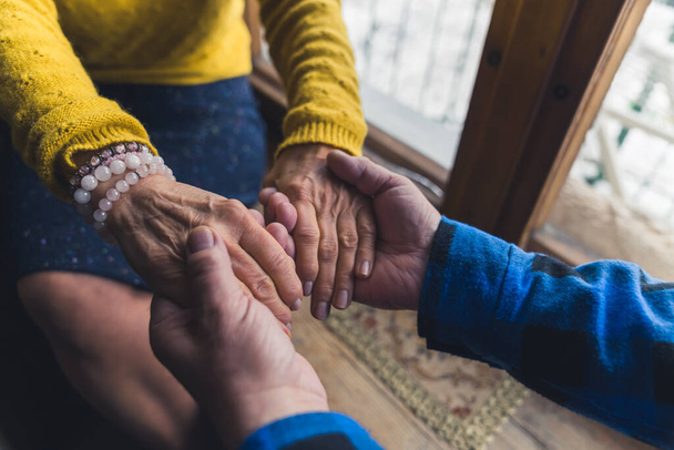 na zawsze razem - para seniorów trzymająca się za ręce przy oknie starsi ludzie kochają i wspierają koncepcję. Wysokiej jakości zdjęcie - Zdjęcie, obraz