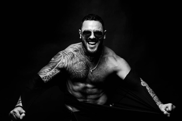 Furious man ripped shirt, isolated on black. Shirtless athletic naked guy - Фото, изображение