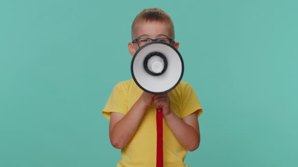 Toddler children boy talking with megaphone, proclaiming news, loudly announcing advertisement sale discount, warning using loudspeaker to shout speech. Young preschool kid isolated on blue background - Séquence, vidéo