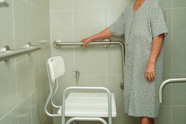 Asiático idoso mulher paciente uso vaso sanitário suporte ferroviário no banheiro, corrimão segurança garra bar, segurança no hospital de enfermagem. - Foto, Imagem