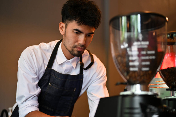 Bonito e profissional asiático barista masculino preparando um café no café. Conceito de negócio de alimentos e bebidas - Foto, Imagem